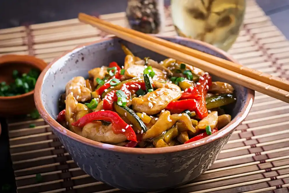 Prato de frango xadrez caseiro com legumes coloridos e molho agridoce.