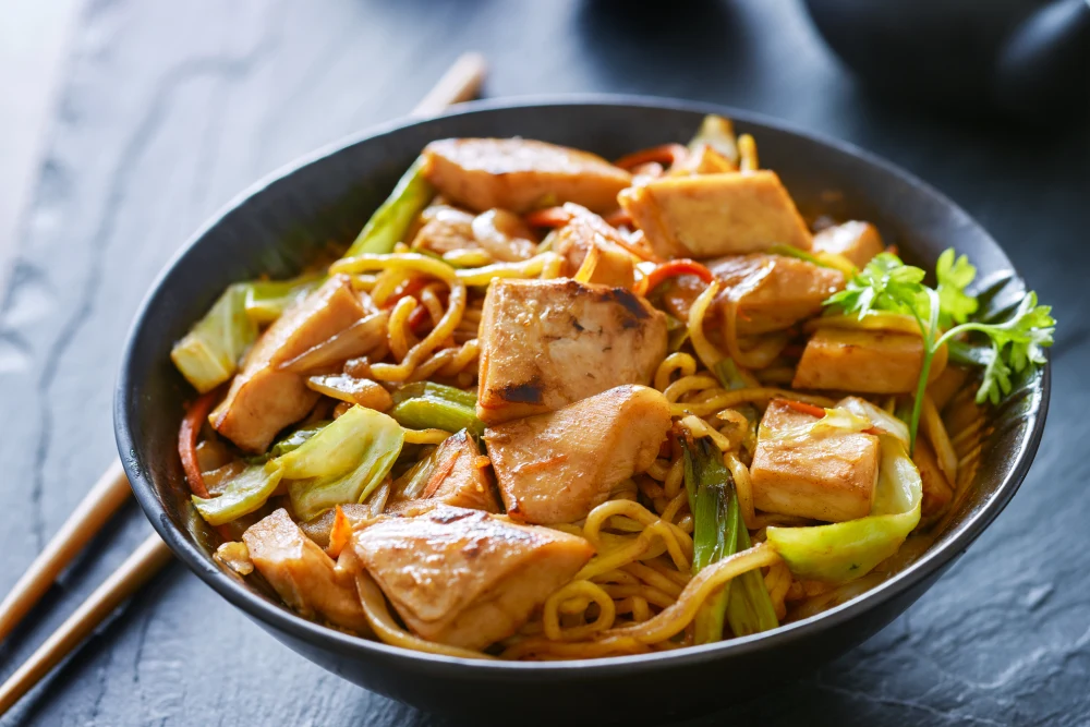 Receita de yakisoba de frango com legumes frescos em uma tigela.