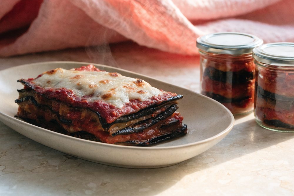 lasanha de berinjela low carb com fatias de berinjela grelhada no lugar da massa, porcionada em potes de vidro para congelar