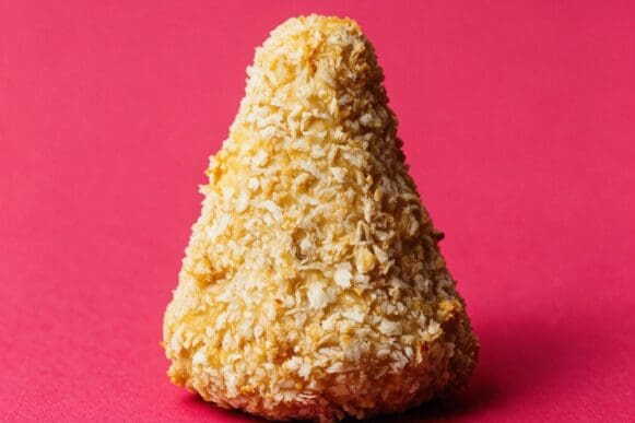 coxinha fit assada e empanada com farinha panko, inteira, sobre fundo rosa da marca Frutifica