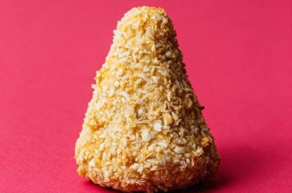 coxinha fit assada e empanada com farinha panko, inteira, sobre fundo rosa da marca Frutifica