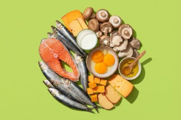 Fontes de vitamina D — salmão, sardinha, gemas de ovo, leite, cogumelos e queijo — sobre fundo verde-limão