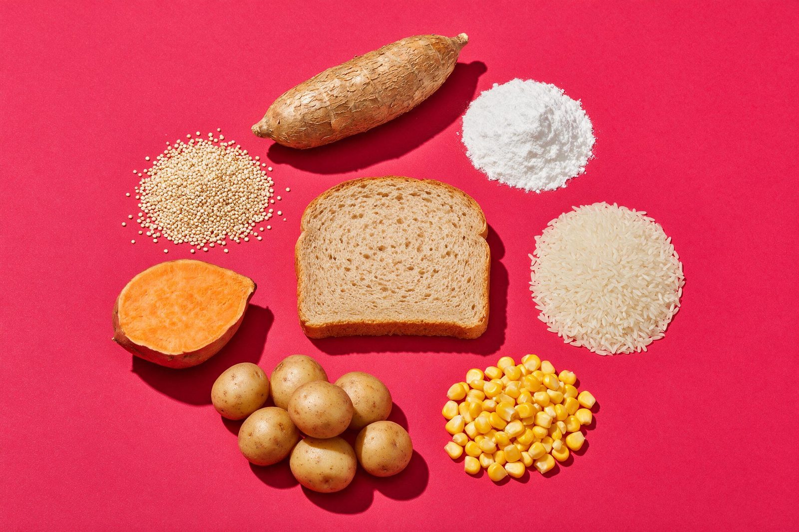 Alimentos naturalmente sem glúten — mandioca, tapioca, arroz, milho, batata, batata-doce, quinoa e pão sem glúten — sobre fundo rosa